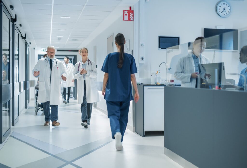 Hospital corridor with healthcare professionals walking and talking to each other