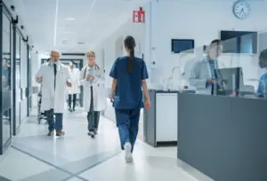Hospital corridor with healthcare professionals walking and talking to each other