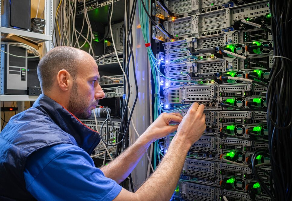 Male IT technician working on a rack in a data centre