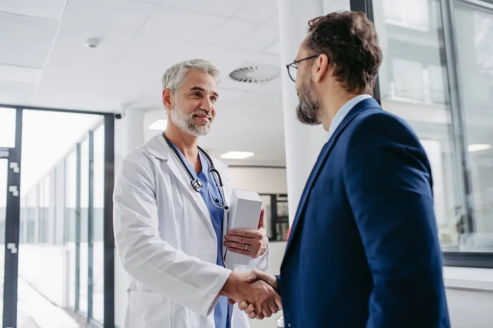 male healthcare professional shaking the hand of a male business consultant