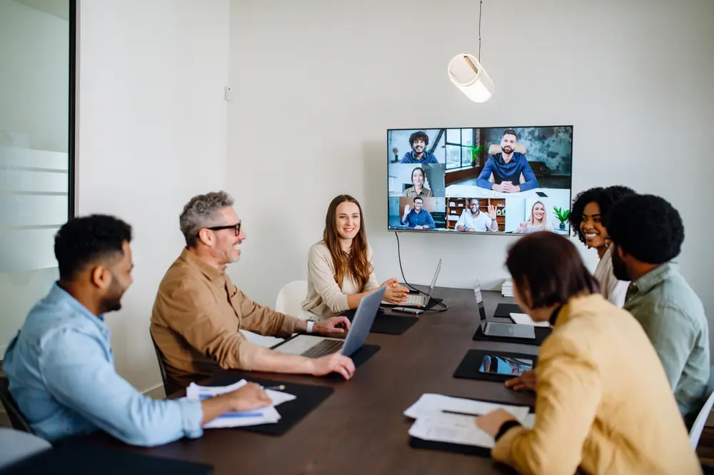 Group of colleagues around a meeting room table smiling