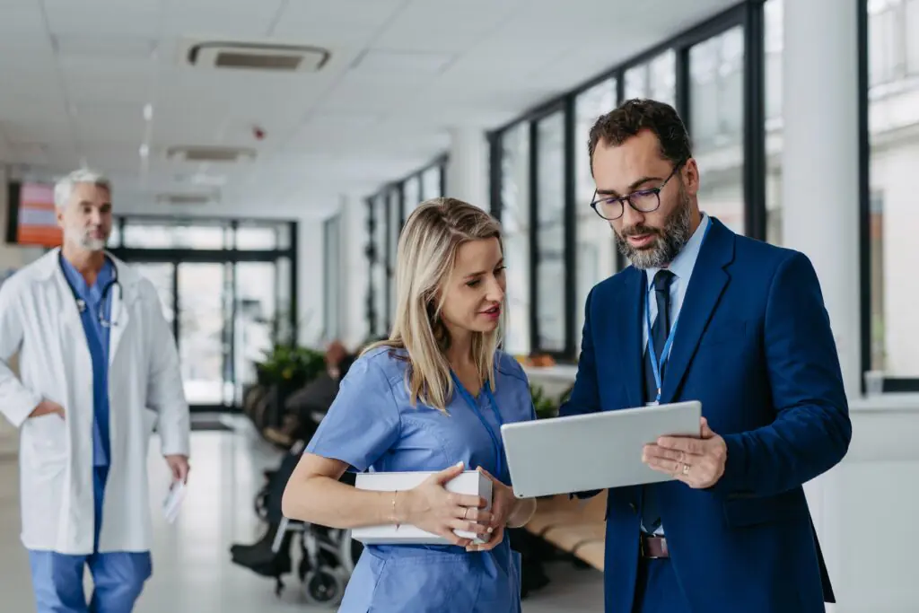 A nurse and business consultant talking about what is being displayed on a tablet in front of them