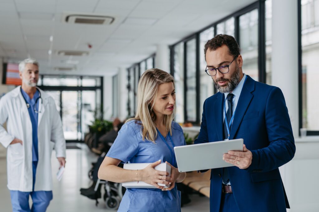 A nurse and business consultant talking about what is being displayed on a tablet in front of them