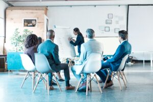 Woman presenting findings on whiteboard to colleagues