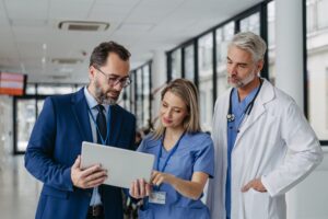two males and one female healthcare professionals looking at a tablet discussing whats on there