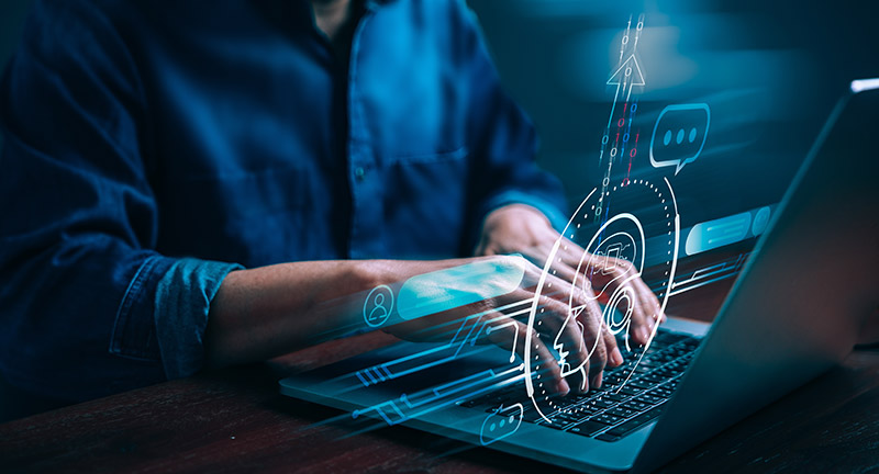 Man typing at laptop with screen digital overlay