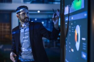 A man stood in front of a projector talking through graphs