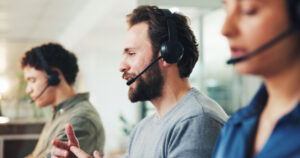 Male talking into headset, smiling and being attentive