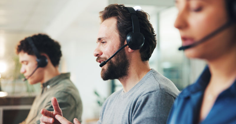 Male talking into headset, smiling and being attentive
